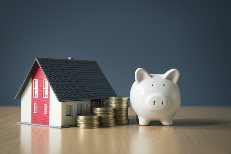 Miniature house with Piggy bank and coins